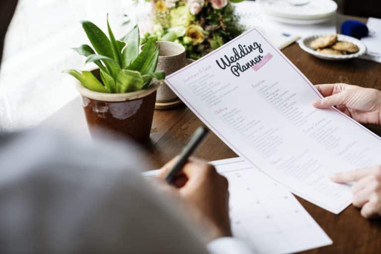 Hands holding wedding planner checklist information preparation