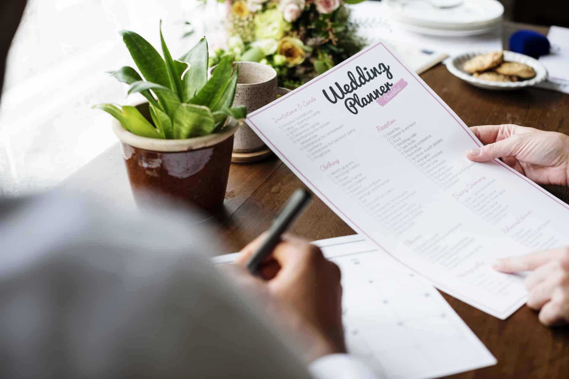 Hands holding wedding planner checklist information preparation